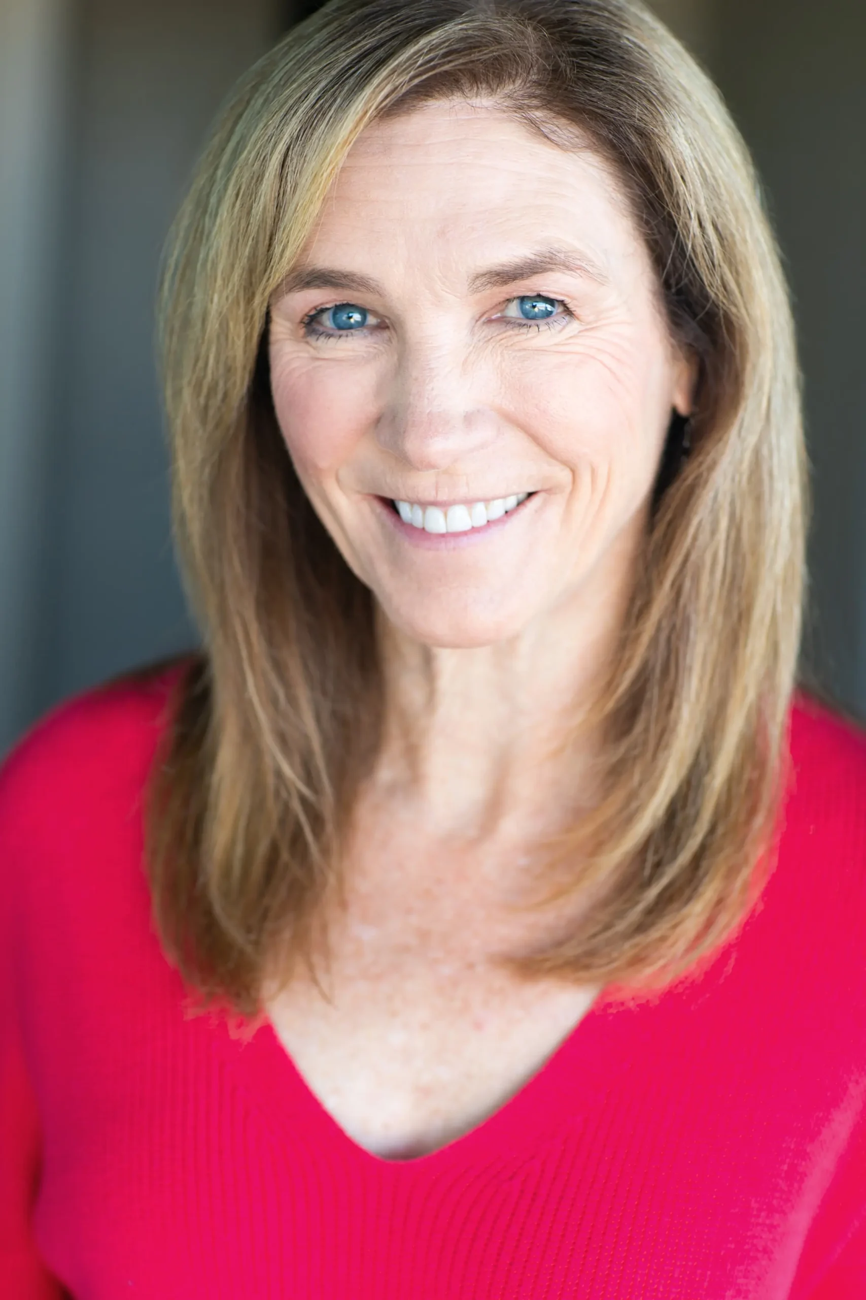 Margie Valine, female voice actor, wearing a pink-red sweater